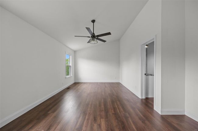 Unfurnished room featuring dark wood-style flooring, a ceiling fan, vaulted ceiling, and baseboards | Image 35