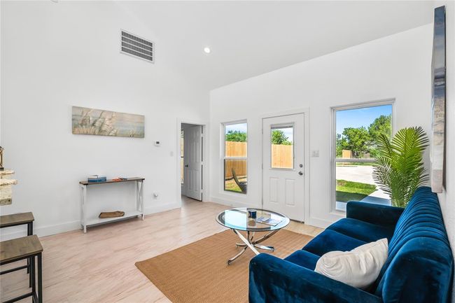Bright and inviting living room with high ceilings, modern finishes, and abundant natural light from large windows. | Image 8