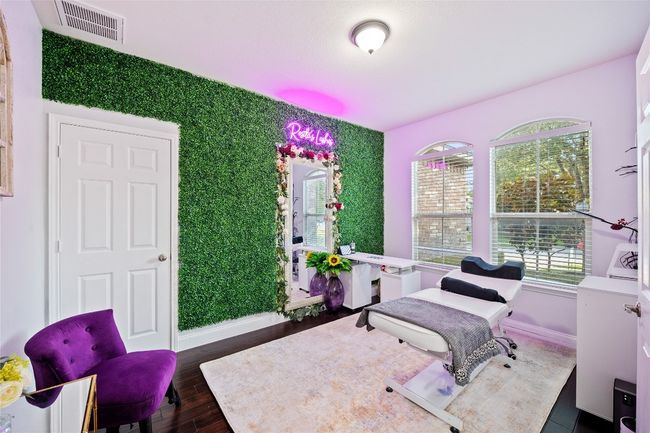 Bedroom with an accent wall and dark wood finished floors | Image 21