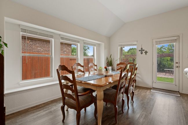 Dining area featuring plenty of natural light, lofted ceiling, wood finished floors, and baseboards | Image 7