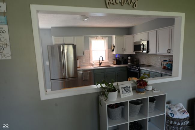 kitchen featuring white cabinets, appliances with stainless steel finishes, tasteful backsplash, and a sink | Image 32