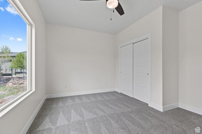 Unfurnished bedroom with baseboards, carpet flooring, a closet, and multiple windows | Image 36