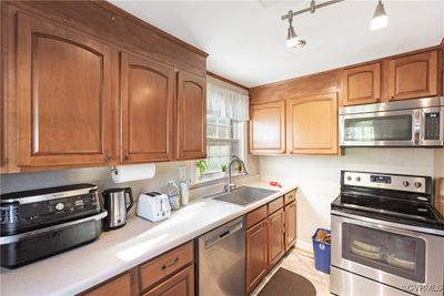 Kitchen featuring sink and appliances with stainless steel finishes | Image 3