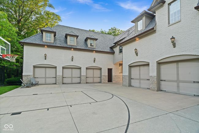 view of front of house featuring a high end roof, stone siding, brick siding, and a garage | Image 109