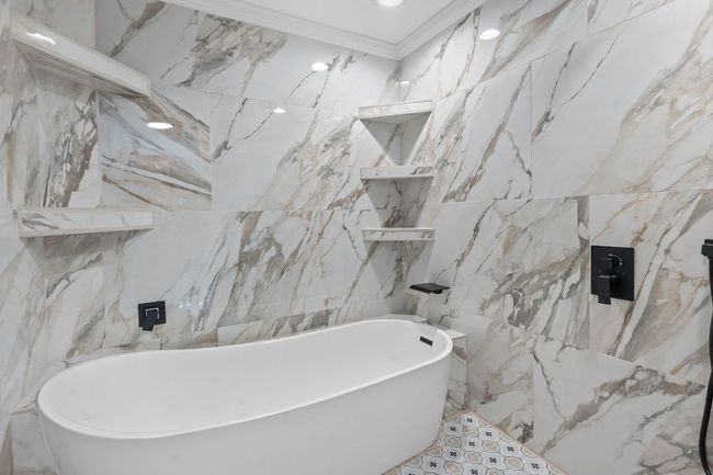 Bathroom featuring tile walls, a freestanding tub, and ornamental molding | Image 23