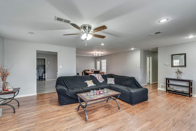 Living area featuring visible vents, baseboards, ceiling fan, and light wood finished floors | Image 10