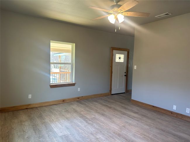 Unfurnished room with a ceiling fan, visible vents, baseboards, and wood finished floors | Image 5