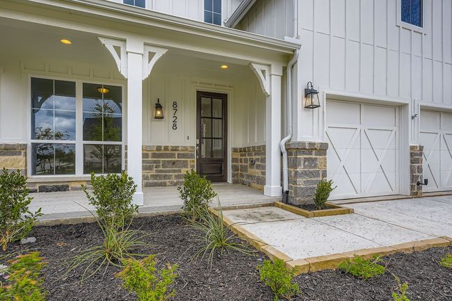 Entrance to property featuring board and batten siding, covered porch, and stone siding | Image 4