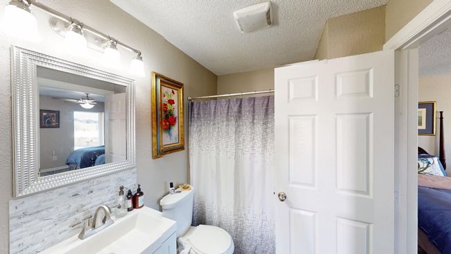Guest Quarters Bathroom featuring toilet, vanity, a textured ceiling, and ensuite bathroom | Image 26