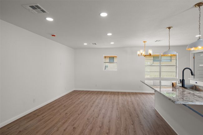 Unfurnished living room with a sink, light wood-style floors, healthy amount of natural light, baseboards, and recessed lighting | Image 11