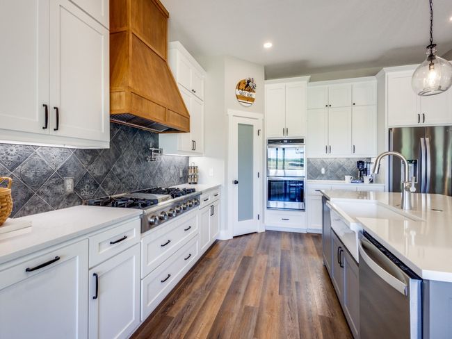 Stainless steel appliances with a built-in gas range, double ovens, and microwave. Notice the location of each appliance specifically placed for an effortless flow while cooking. Extensive storage as well as extensive counter top space--this kitchen is a dream for the chef in the family! | Image 12