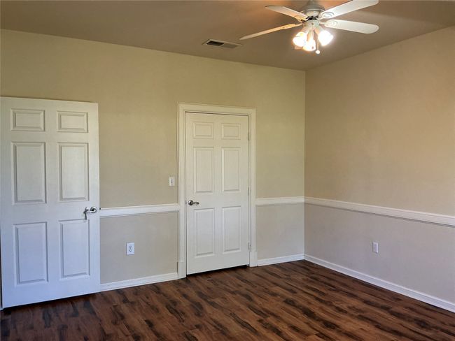 Empty room with baseboards, visible vents, ceiling fan, and dark wood finished floors | Image 17