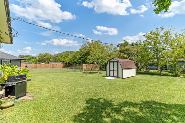 Spacious backyard featuring a storage shed and plenty of room for leisure activities, entertaining guests, or future improvements to create your ideal outdoor space. | Image 22