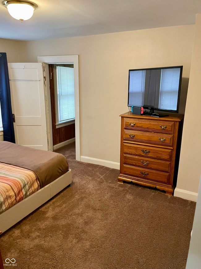 bedroom with dark colored carpet and baseboards | Image 11
