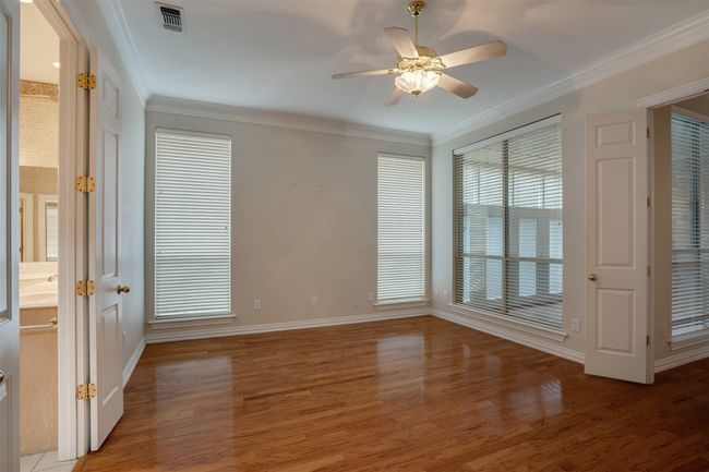 Spare room featuring light wood-style flooring, ceiling fan, crown molding, and baseboards | Image 17