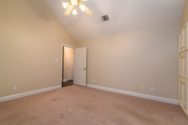 Unfurnished bedroom featuring carpet floors, lofted ceiling, baseboards, and a ceiling fan | Image 10