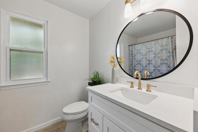 The guest bathroom is thoughtfully designed with recent updates, including a modern vanity, sleek mirrors, and stylish fixtures for a fresh, welcoming feel. | Image 23