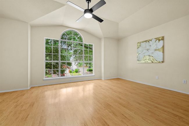 Unfurnished room with ceiling fan, wood finished floors, and lofted ceiling | Image 19