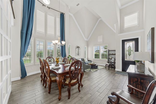 Dining room featuring high vaulted ceiling, a chandelier, plenty of natural light, and baseboards | Image 8