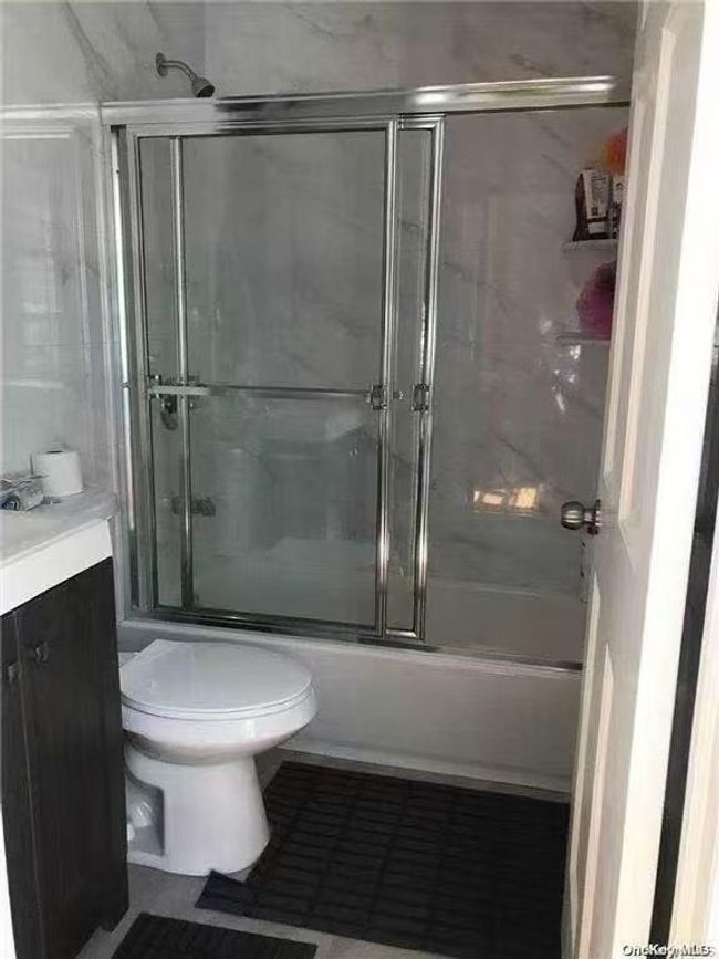 Bathroom featuring vanity, combined bath / shower with glass door, and tile patterned flooring | Image 5