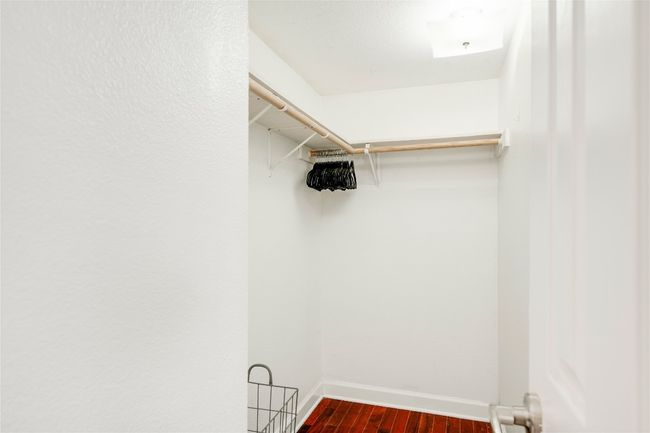 Spacious closet with dark wood-type flooring | Image 25