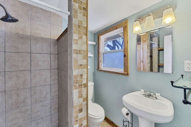 Bathroom featuring toilet, a tile shower, and a sink | Image 19