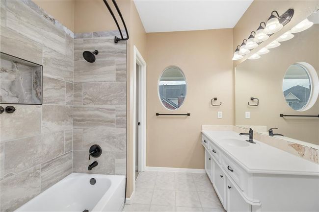 Sleek, stylish, and updated in 2024 with today’s finishes, the secondary bath serves as a polished retreat for guests or family. Durable tile flooring, a refined vanity, and a tub-shower combo offer both form and function in a calming palette. | Image 42