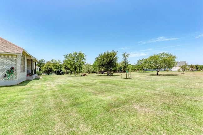 Enjoy the treed backyard to its fullest! There's a zipline installed for the kiddos, as well as a playscape; a firepit for gatherings. Best of all, there's plenty of space to realize your dream - perhaps a gazebo? Hot tub? Horseshoes? Garden? Flower beds? Fruit trees? Swimming pool? | Image 20