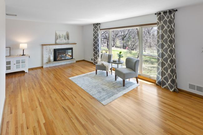 Spacious living room with wall of windows to enjoy natural light and private back yard views. | Image 6
