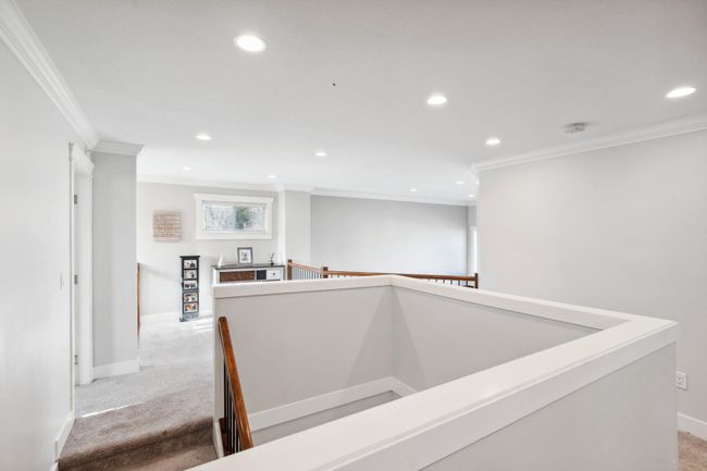 Hall with recessed lighting, an upstairs landing, light carpet, and baseboards | Image 14