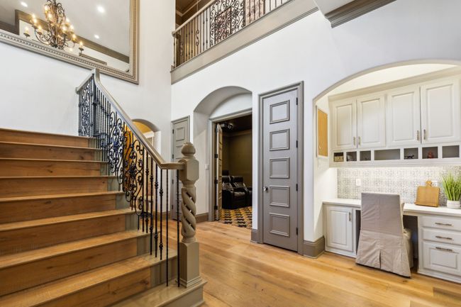 A Stunning Wood Plank Staircase with Elegant Iron Banisters Guides You to the Upstairs Retreat | Image 24