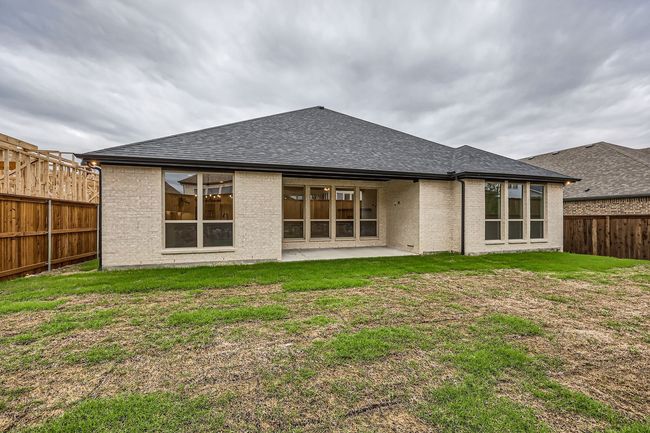 Back of house featuring brick siding, roof with shingles, a lawn, and a fenced backyard | Image 28