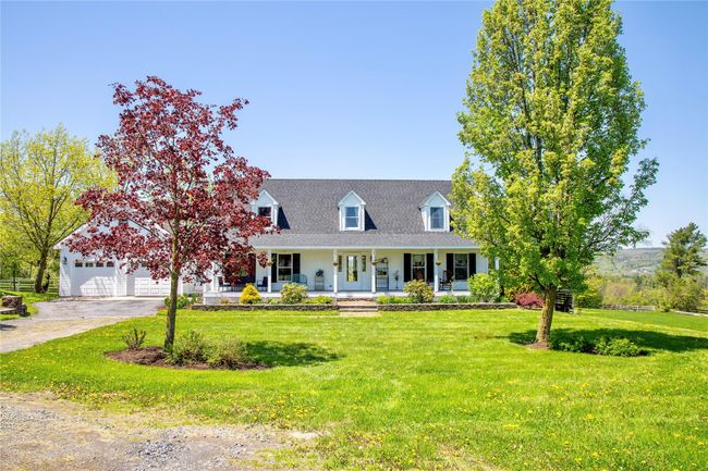 Cape cod-style house with a porch, a front lawn, and a shingled roof | Image 44