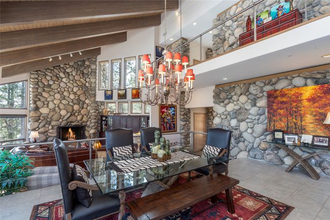 Dining room with high vaulted ceiling, a wealth of natural light, a stone fireplace, and beamed ceiling | Image 13