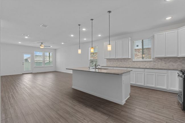 Kitchen with recessed lighting, a ceiling fan, backsplash, white cabinets, and light stone counters | Image 5