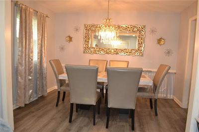 Dining area featuring a notable chandelier and dark hardwood / wood-style flooring | Image 3