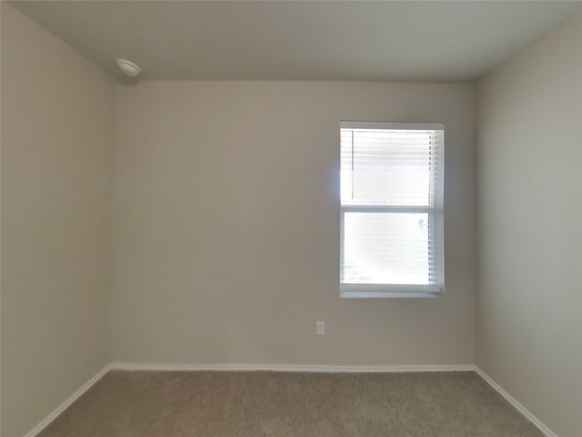Carpeted spare room featuring baseboards and a smoke detector | Image 10