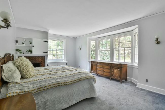 Bedroom featuring crown moldings, walk-in closet, ensuite bath, original built-ins and fireplace | Image 18