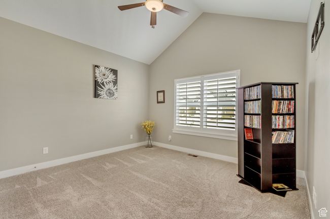 Carpeted spare room with high vaulted ceiling, baseboards, a ceiling fan, and visible vents | Image 25