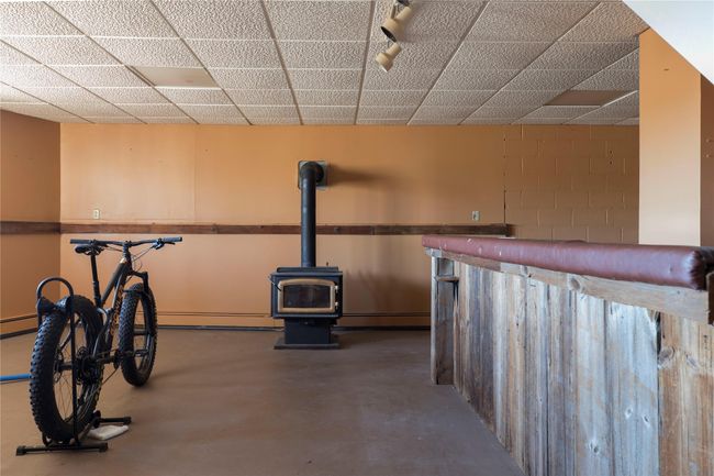 Exercise room with a baseboard radiator, a dry bar, and a wood stove | Image 27