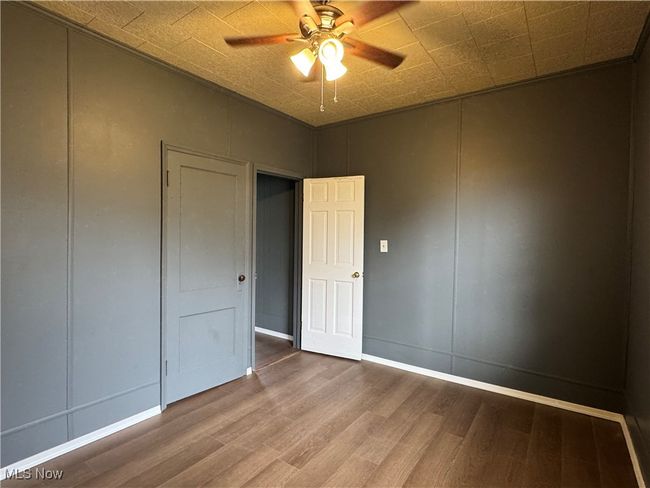Unfurnished bedroom featuring hardwood / wood-style floors and ceiling fan | Image 14