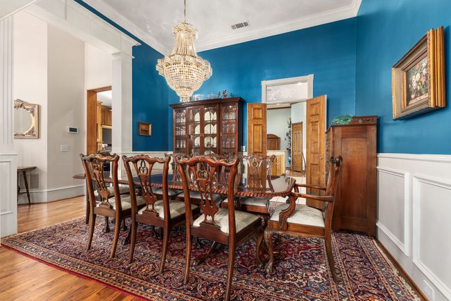 Dining room featuring wood finished floors, a notable chandelier, and ornamental molding | Image 5