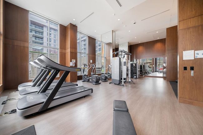 Workout area with wood finished floors, expansive windows, and wooden walls | Image 26