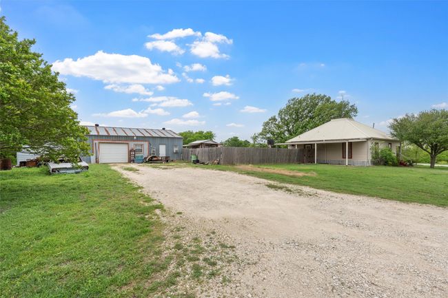 View of front of property with driveway, an outdoor structure, fence, a front lawn, and a garage | Image 20