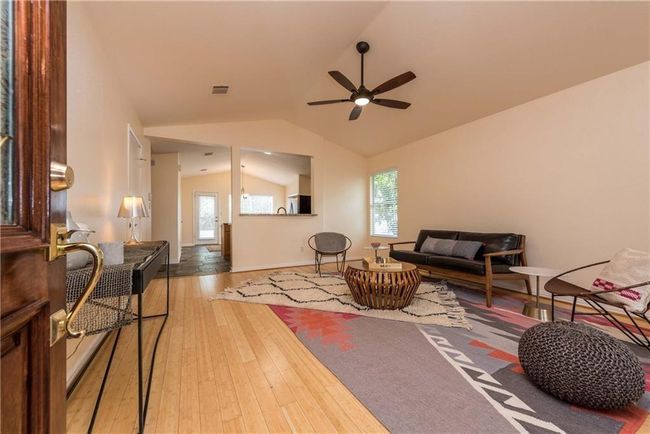 Living area with lofted ceiling, a ceiling fan, healthy amount of natural light, and wood-type flooring | Image 19
