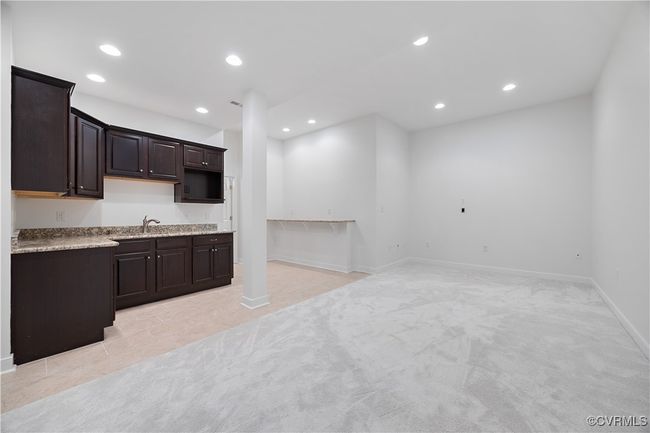 Kitchen with recessed lighting, dark brown cabinets, light carpet and tiled floor, a sink | Image 44