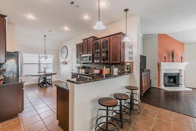 Kitchen with tile patterned flooring, visible vents, stainless steel appliances, and decorative backsplash | Image 6
