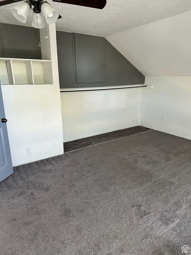Bonus room featuring dark colored carpet, ceiling fan, a textured ceiling, and vaulted ceiling | Image 21