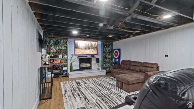 Living room with wood finished floors, wooden walls, and a fireplace | Image 15