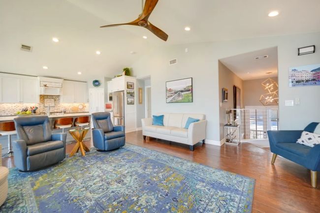 Living room featuring a ceiling fan, wood finished floors, high vaulted ceiling, recessed lighting, and a chandelier | Image 20